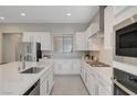 Modern kitchen with stainless steel appliances, white cabinets, and a large center island with sink at 10251 Tiger Milkweed St, Las Vegas, NV 89141