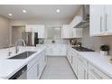 Bright kitchen with white cabinets, gray backsplash, stainless appliances, and a kitchen island at 10251 Tiger Milkweed St, Las Vegas, NV 89141