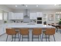 Modern kitchen with large island, stainless steel appliances, and sleek finishes open to dining area at 10251 Tiger Milkweed St, Las Vegas, NV 89141