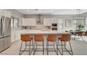 Modern kitchen boasts stainless steel appliances, a center island with bar seating, and bright, white cabinets at 10251 Tiger Milkweed St, Las Vegas, NV 89141