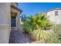 A covered front entrance with a brick walkway leading to a well-maintained garden at 104 Pollentia Ave, North Las Vegas, NV 89084