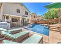 Inviting backyard featuring a sparkling pool, lounge chairs, and covered patio, perfect for outdoor living at 11143 Castellane Dr, Las Vegas, NV 89141