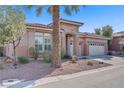Desert home featuring muted colors, a three car garage, and minimalist landscaping at 11369 Rancho Villa Verde Pl, Las Vegas, NV 89138