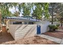 Charming single-story home with blue tile roof, gated courtyard, and mature trees in a well-maintained community at 2128 Petersham Ct # C, Las Vegas, NV 89108