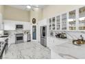 Bright and airy kitchen featuring modern white cabinets, stainless steel appliances, and marble countertops at 2209 Glenbrook Way, Las Vegas, NV 89117