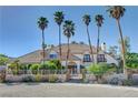 Stately home showcasing mature palm trees, a tile roof, and gated courtyard at 2771 S Buffalo Dr, Las Vegas, NV 89117