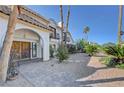 A welcoming view of the home's entrance, showcasing a paver walkway and ample vegetation at 2771 S Buffalo Dr, Las Vegas, NV 89117