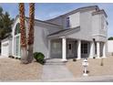 Inviting single-Gathering home with stucco exterior, desert landscaping, and a columned front porch entrance at 2830 Queens Courtyard Dr, Las Vegas, NV 89109