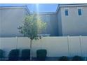 Enclosed backyard featuring a white fence and minimal landscaping with greenery and small trees at 2872 Atomic Tangerine Way # 2, Las Vegas, NV 89183