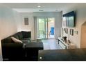 Inviting living room with a comfortable sectional sofa, sliding glass doors, and a sleek entertainment center at 2872 Atomic Tangerine Way # 2, Las Vegas, NV 89183