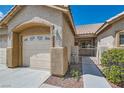 A close-up view of a home's two-car garage, and gated entry surrounded by well-maintained landscaping at 427 Rhythm St, Henderson, NV 89074