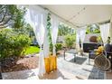 Relaxing covered patio with string lights, lounge seating, and lush greenery, perfect for outdoor entertaining at 504 Painted Cloud Pl, Las Vegas, NV 89144