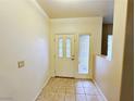 Inviting entryway featuring neutral walls, tiled flooring, and a decorative front door with side window at 5704 Burdel St, Las Vegas, NV 89149