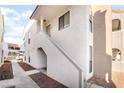 Exterior shot of white condo building with staircase leading to upper-level apartments at 611 Bass Dr # C, Henderson, NV 89014