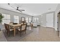 Staged open-concept living room, showcasing dining area, tile floors, and plenty of natural light at 6150 Bunker Commons Ct, Las Vegas, NV 89108