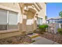 Exterior view of a home's entrance, showcasing a white door, windows, and trimmed landscaping at 6420 Extreme Shear Ave # 102, Henderson, NV 89011