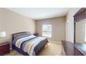 Neutral bedroom with a queen bed, wood furniture, and natural light from the exterior window at 6901 Cobre Azul Ave # 202, Las Vegas, NV 89108