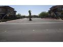A paved entry road with a decorative median leads to a gated residential complex at 833 Aspen Peak Loop # 1524, Henderson, NV 89011