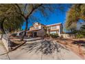 Charming two-story home with a long driveway and mature trees providing ample shade at 884 E Robindale Rd, Las Vegas, NV 89123