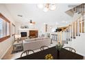 Bright, open-concept living room featuring fireplace, stairs, and seamless transition to kitchen at 9490 Thunder Sky St # 102, Las Vegas, NV 89178
