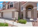 Close up on the home's front entrance featuring an arched entryway and desert landscaping at 124 Wynntry Dr, Henderson, NV 89074