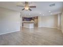 Open-concept living room flowing into the kitchen, featuring wood floors and ample natural light at 1525 Spiced Wine Ave # 19103, Henderson, NV 89074