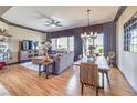 Open-concept living and dining area with hardwood floors, a ceiling fan, and large windows at 1564 Fieldbrook St, Henderson, NV 89052