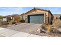 Charming single-story home featuring a two-car garage, stone accents, and desert landscaping at 2128 Delmar Farms Ct, Laughlin, NV 89029