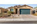 Charming single-story home featuring a two-car garage, stone accents, and desert landscaping at 2128 Delmar Farms Ct, Laughlin, NV 89029