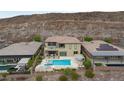 An aerial view of a luxurious backyard with a pool, spa, outdoor kitchen, and manicured landscaping at 2153 King Crest Ct, Henderson, NV 89052