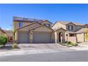 Charming two-story home with a three-car garage, brick driveway, and solar panels at 242 Polaris Ridge Ave, Henderson, NV 89011