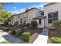 Charming exterior of a townhome with landscaped front yard and a concrete walkway at 2461 Old Forge Ln # 103, Las Vegas, NV 89121