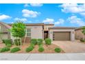 Charming exterior showcasing an attached garage, complemented by lush front yard landscaping at 2654 Summit Springs St, Henderson, NV 89044