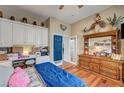 Cozy bedroom with hardwood floors, lots of decorations, and a doorway to another room at 2939 Crown Bluffs Ct, Las Vegas, NV 89117