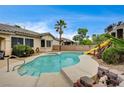 Private backyard pool and spa with a slide, perfect for outdoor relaxation and entertainment at 2939 Crown Bluffs Ct, Las Vegas, NV 89117