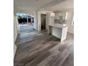 View of living area with sleek wood floors, island, and sliding doors to the backyard at 321 Beaumont St, Las Vegas, NV 89106