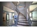 Grand entryway featuring a winding staircase, grey walls, and marble floors at 4732 Illustrious St, Las Vegas, NV 89147
