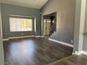 Spacious living room with hardwood floors, grey walls, large window, and natural light at 4732 Illustrious St, Las Vegas, NV 89147