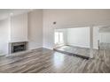 Bright living room featuring gray-washed wood floors, a fireplace, and ample natural light at 4889 W Montara Cir, Las Vegas, NV 89121