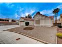 A well-maintained front yard shows a home with desert landscaping and a charming brick fire pit at 5124 Appealing Ct, Las Vegas, NV 89130