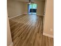Bright living room with wood-look flooring, ceiling fan, and balcony access at 555 E Silverado Ranch Blvd # 1034, Las Vegas, NV 89183
