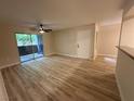 Living room with wood-look flooring, ceiling fan, and sliding glass doors to patio at 555 E Silverado Ranch Blvd # 1034, Las Vegas, NV 89183