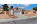 Single-story home with a two-car garage and desert landscaping at 5900 Red Umber Ave, Las Vegas, NV 89130