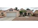 Single story home with desert landscaping, covered porch, dormer windows and a two car garage at 5900 Red Umber Ave, Las Vegas, NV 89130