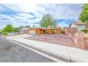 Front exterior view showcasing mature landscaping, desert landscaping and large driveway at 632 Arrayo Way, Boulder City, NV 89005