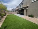 Expansive backyard with artificial grass and a covered patio perfect for outdoor entertaining at 7527 Ardenno St, North Las Vegas, NV 89084