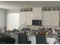 Bright kitchen featuring white cabinets, stainless steel appliances, and granite countertops at 7527 Ardenno St, North Las Vegas, NV 89084