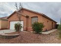 Inviting single-story home featuring a two-car garage, tiled roof, and desert-friendly landscaping at 7535 Frontier Ranch Ln, Las Vegas, NV 89113