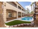 Relaxing backyard with a refreshing pool, manicured landscaping, and a covered patio area at 7616 Gossamer Wind St, Las Vegas, NV 89139