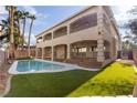 Beautiful backyard with a sparkling pool, covered patio, and lush artificial grass at 7616 Gossamer Wind St, Las Vegas, NV 89139